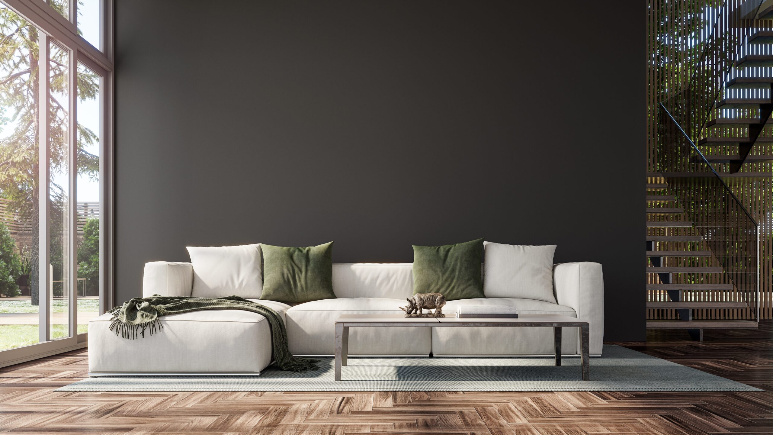 Modern,Interior,Design,With,Staircase,And,Empty,Black,Mock,Up Modern living room with a white sectional sofa, green and white pillows, a glass coffee table, and large windows. Wood flooring and a staircase are visible.